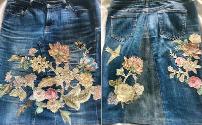 Upcycled Jeans skirt. Image shows a jeans skirt decorated with applique flowers