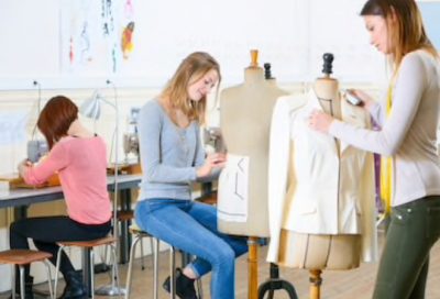 Summer School:Dressmaking course - young women fitting clothes on a mannequin