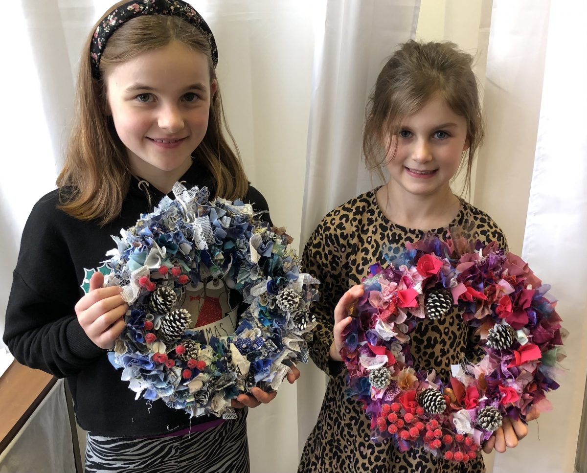 Rag Wreath - girls showing the christmas decorations they've made from fabric scraps